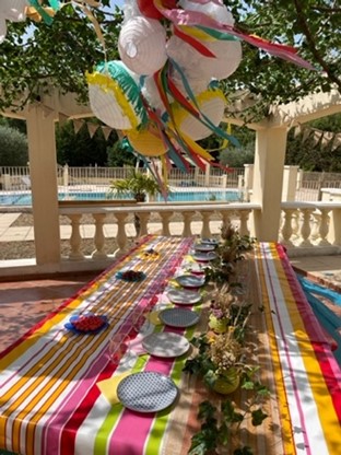 Une table dressée pour le repas avec des ballons gonflables au dessus