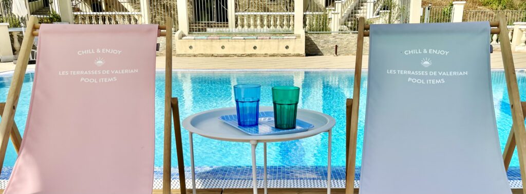 2 transat avec le nom du domaine "Terrasses de Valerian" entourant 2 verres colorés, posés sur une table basse