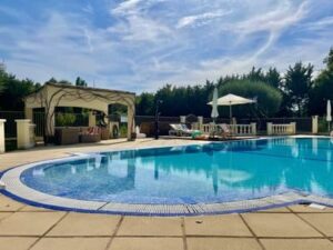 Une piscine et un poolhouse en second plan