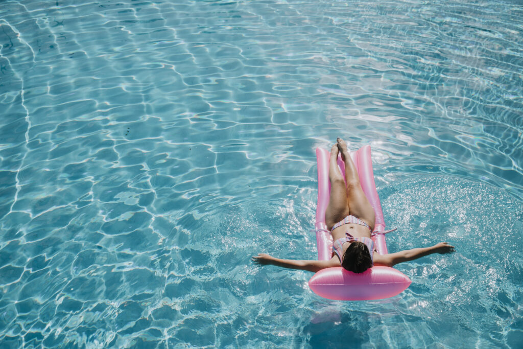 femme relax sur matelas au milieu d'une piscine